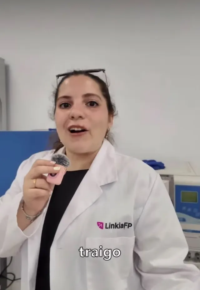 Portada de un reel de la campaña de Linkia FP en Instagram: una chica con bata blanca con el logotipo de Linkia FP sostiene un micrófono de solapa en un laboratorio